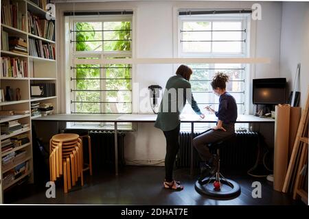 Full length of female architects discussing at table in office Stock Photo