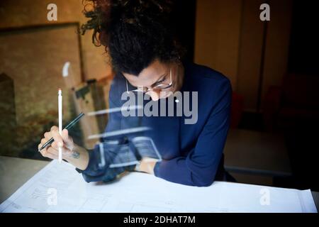 Female architect working at table in office Stock Photo