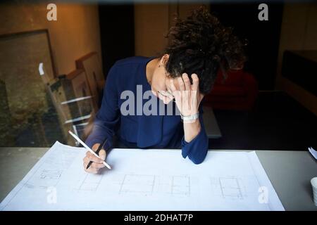 Female tensed architect working at table in office Stock Photo