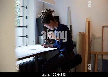 Side view of confident female architect working at table in office Stock Photo