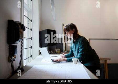 Confident female architect using laptop in office Stock Photo