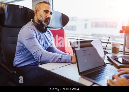 Thoughtful businessman looking away while traveling in train Stock Photo