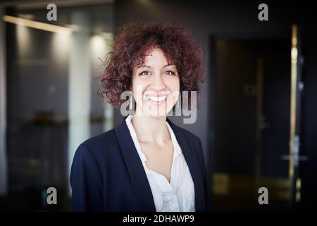 Portrait of smiling female legal professional with curly hair at office Stock Photo