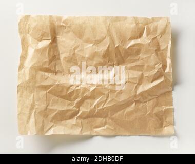 crumpled brown baking paper sheet on white table, top view Stock Photo