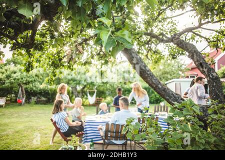 Friends and family enjoying at garden party in backyard during weekend Stock Photo