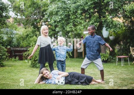 Multi-ethnic group of male and female friends having fun in backyard Stock Photo