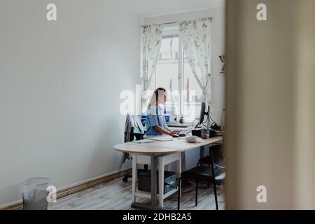Female doctor working on computer at office desk in hospital Stock Photo