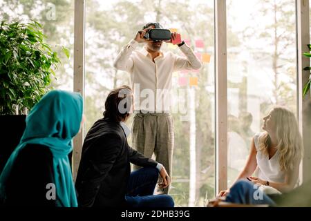 Businessman wearing virtual reality simulator during conference at convention center Stock Photo