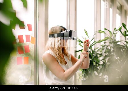 Businesswoman wearing virtual reality simulator at convention center Stock Photo