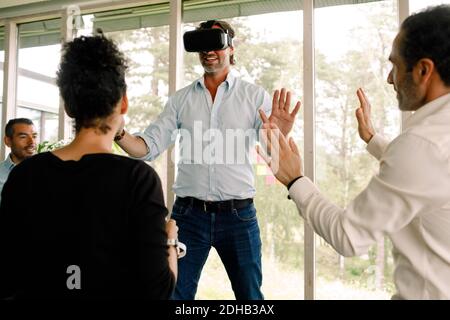 Businessman gesturing while wearing virtual reality simulator at convention center Stock Photo