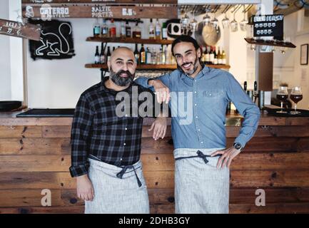 Portrait of male partners standing at bar counter Stock Photo