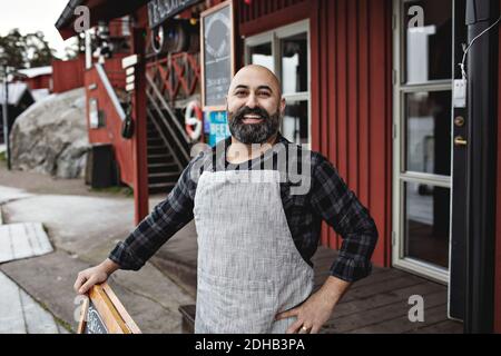 Portrait of smiling worker standing against factory Stock Photo