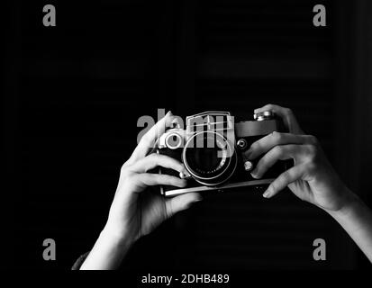 hands holding old analogue camera, taking photos Stock Photo