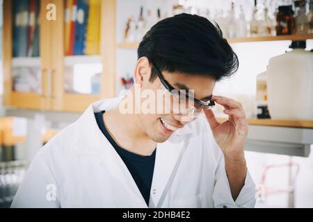 Confident young male student wearing protective eyewear in chemistry laboratory Stock Photo