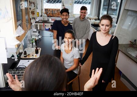 High angle view of female teacher explaining to happy multi-ethnic students at chemistry laboratory Stock Photo