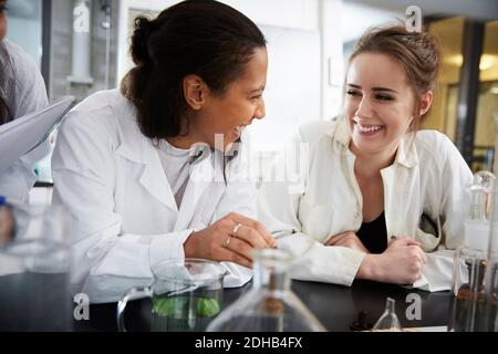Cheerful young multi-ethnic chemistry students sitting at laboratory in university Stock Photo