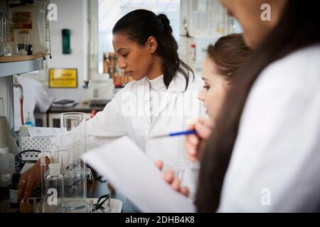 Female students with teacher studying in chemistry laboratory Stock Photo