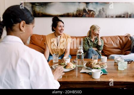 Happy business people having snack and coffee during break in office Stock Photo
