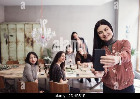 Smiling woman taking selfie with female colleagues at workshop Stock Photo