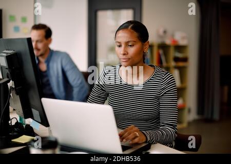 Businesswoman contemplating while using laptop at office desk Stock Photo