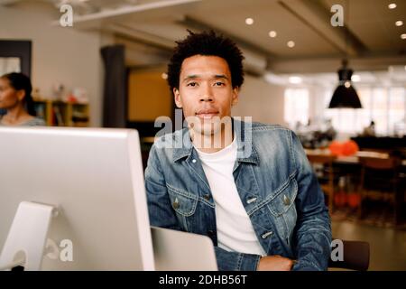 Portrait of confident young businessman sitting in office Stock Photo