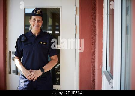 Portrait of smiling policewoman standing outside police station Stock Photo