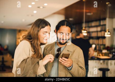 Couple using smart phone while standing in hotel Stock Photo