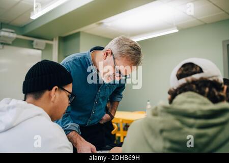 Male teacher teaching students in classroom Stock Photo