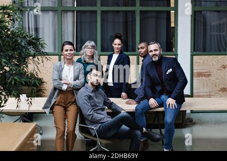 Portrait of confident business team at table in creative office Stock Photo