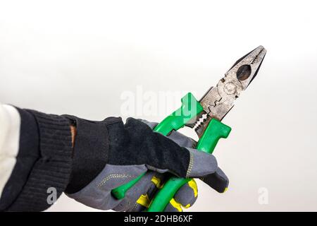 Worker tool at work, old pliers in hand on white background Stock Photo