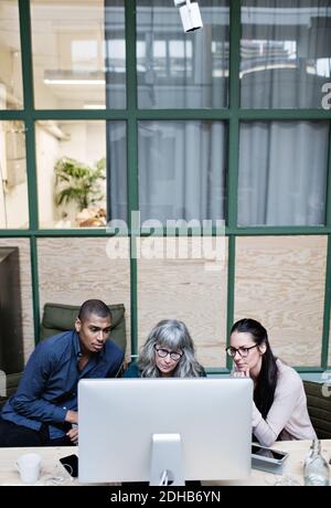 High angle view of male and female business people looking at desktop computer in office Stock Photo