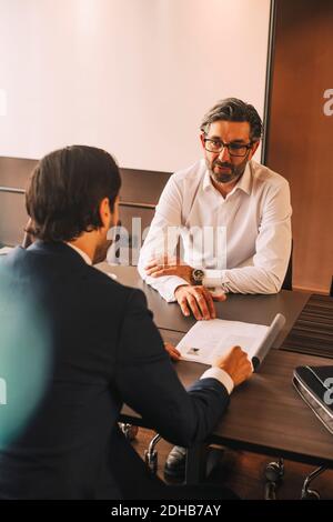 High angle view of advisor explaining document to businessman in meeting at law office Stock Photo