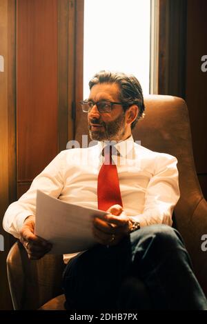 Confident mature legal professional reviewing documents at law office Stock Photo