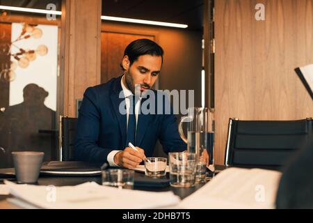 Serious male financial advisor reviewing documents at legal office Stock Photo