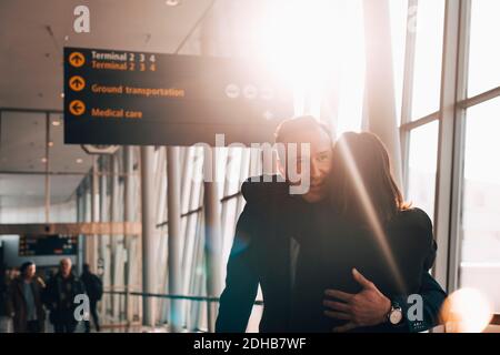 Business couple embracing in airport terminal Stock Photo