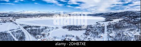 Scenic aerial view on Tarna Vilt village and Joesjo lake in Swedish Lapland in winter cover, frosty sunny day. Roads, houses, frozen lakes, birch tree Stock Photo