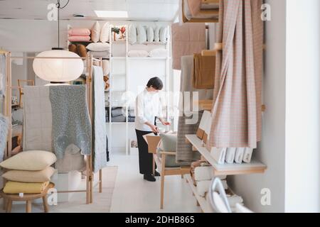 Full length of female interior designer working in workshop Stock Photo