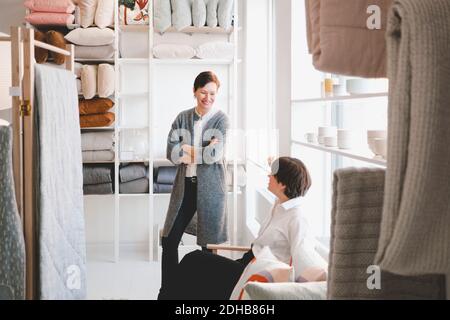 Smiling female designer talking with colleague in store Stock Photo