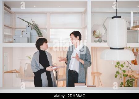 Owner talking with female customer in fashion studio Stock Photo