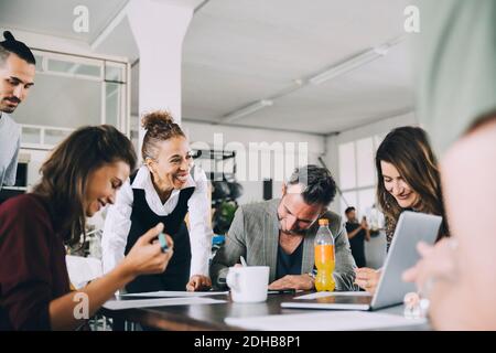 Smiling creative business people working at table in office Stock Photo