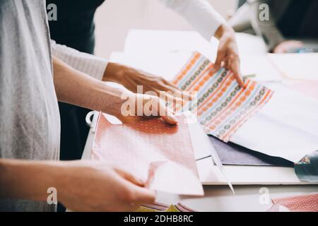 Midsection of creative businessman and businesswoman working at table in office Stock Photo