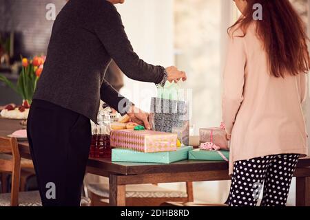 Grandmother and granddaughter arranging gift boxes on table at home Stock Photo