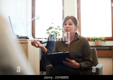 Confident senior counselor discussing with patient at workshop Stock Photo