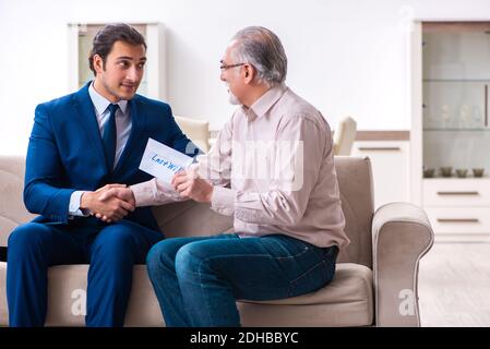 Young male lawyer visiting old man in testament concept Stock Photo