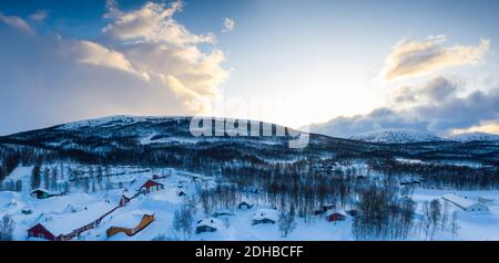 Scenic aerial panorama view on Tarna Vilt village in Joesjo lake area, Swedish Lapland in winter cover, frosty sunny day. Mountain cabins, birch trees Stock Photo