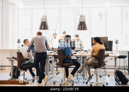 Male and female computer programmers working at desk in creative workplace Stock Photo