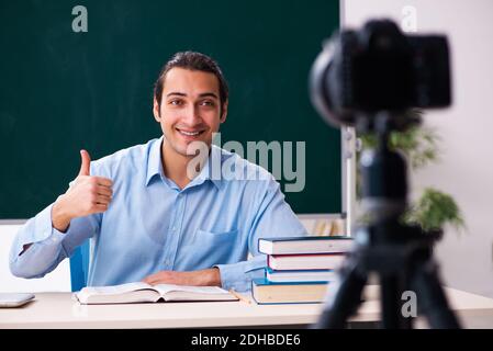 Young handsome teacher recording video for his blog Stock Photo