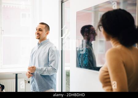Computer programmers giving presentation over code during meeting Stock Photo