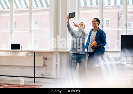 Male computer hackers taking selfie while standing in office Stock Photo