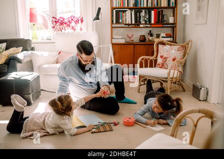 Father playing with daughters in living room at home Stock Photo